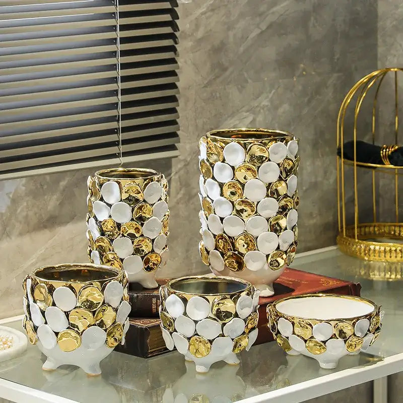 White ceramic vases and bowls with geometric gold leaf relief mosaic and three small feet for living room decor