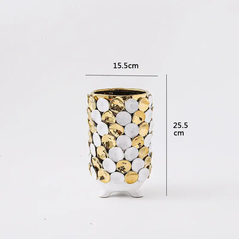A tall ceramic vase with geometric gold leaf relief featuring a glossy white base and gold-trimmed rim for living room decor