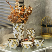 White ceramic vase with geometric gold leaf mosaic pattern and gold leaf relief featuring three small feet for decor