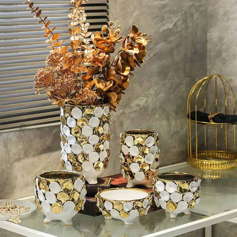 White ceramic vase with geometric gold leaf mosaic pattern and gold leaf relief featuring three small feet for decor