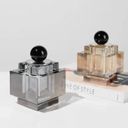 Two geometric storage jars with gold and silver crystal bases and black spherical caps for bedroom jewelry box use