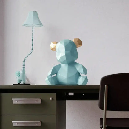 A geometric light blue bear figurine resin sculpture with gold-colored ears for living room decor on a desk