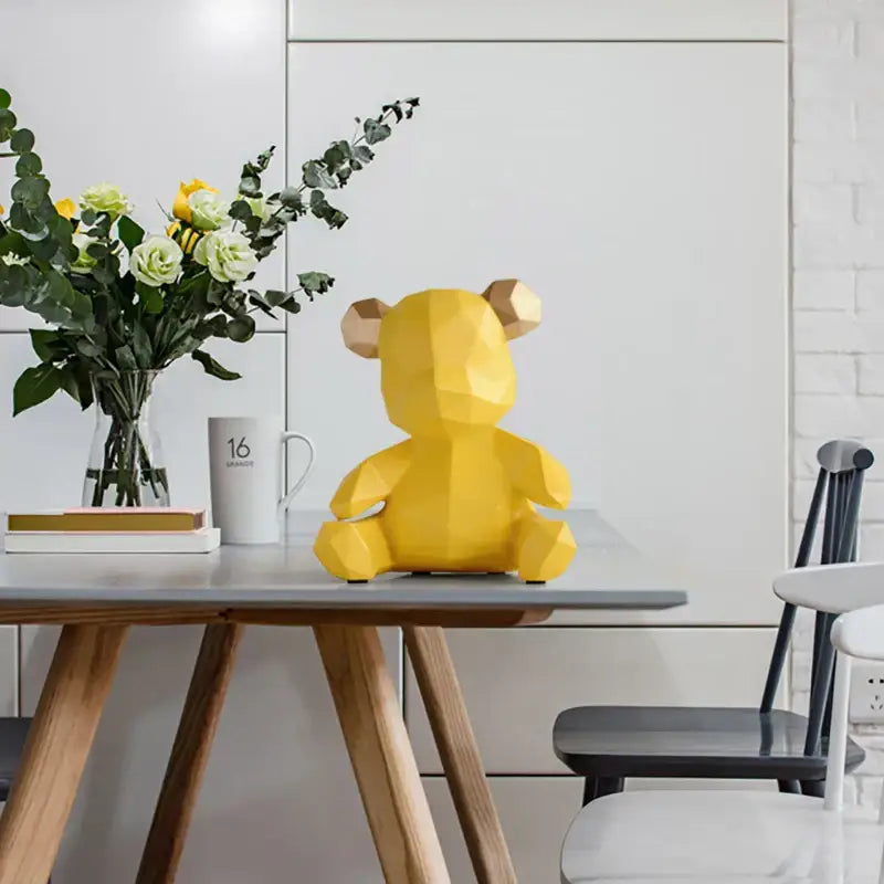 A vibrant yellow geometric bear figurine resin sculpture with faceted design and light brown ears for living room decor