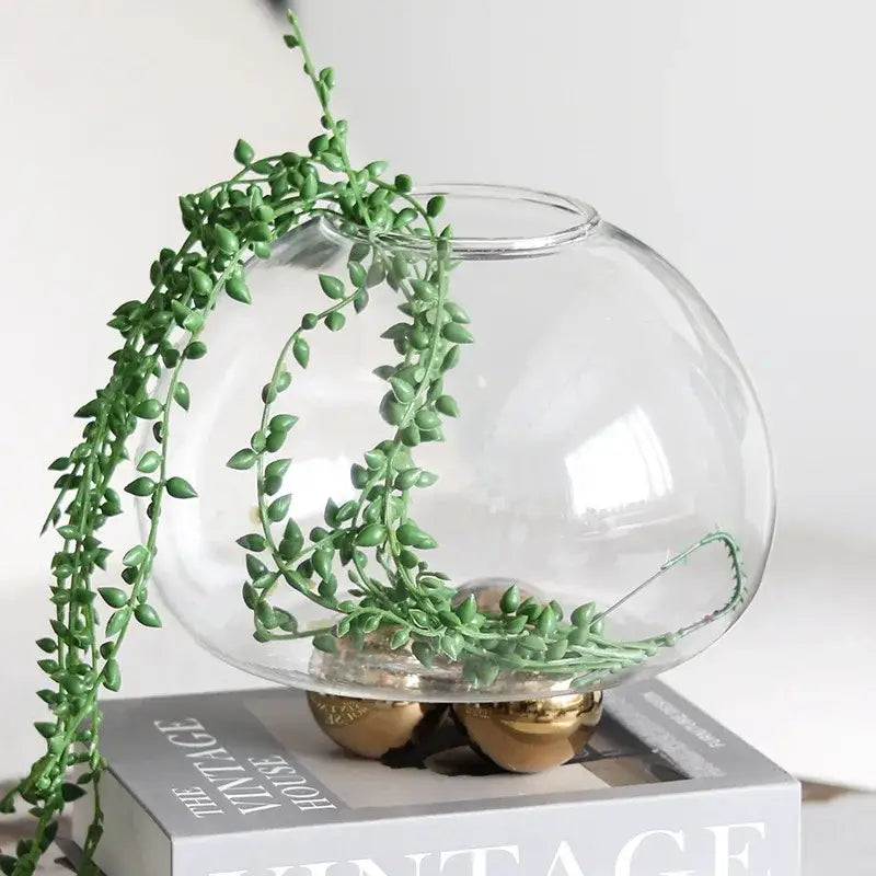 Clear glass spherical vase with green trailing plant inside decorbites geometric golden ball floral decor
