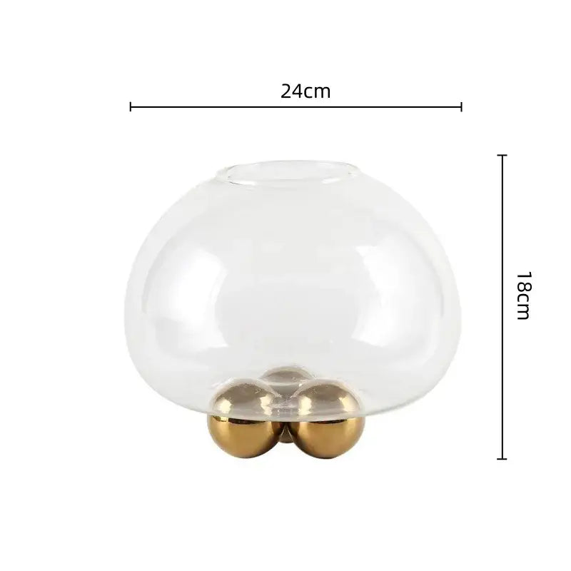 Clear glass dome vase with geometric golden ball design supported by three polished gold-toned spherical feet decorbites