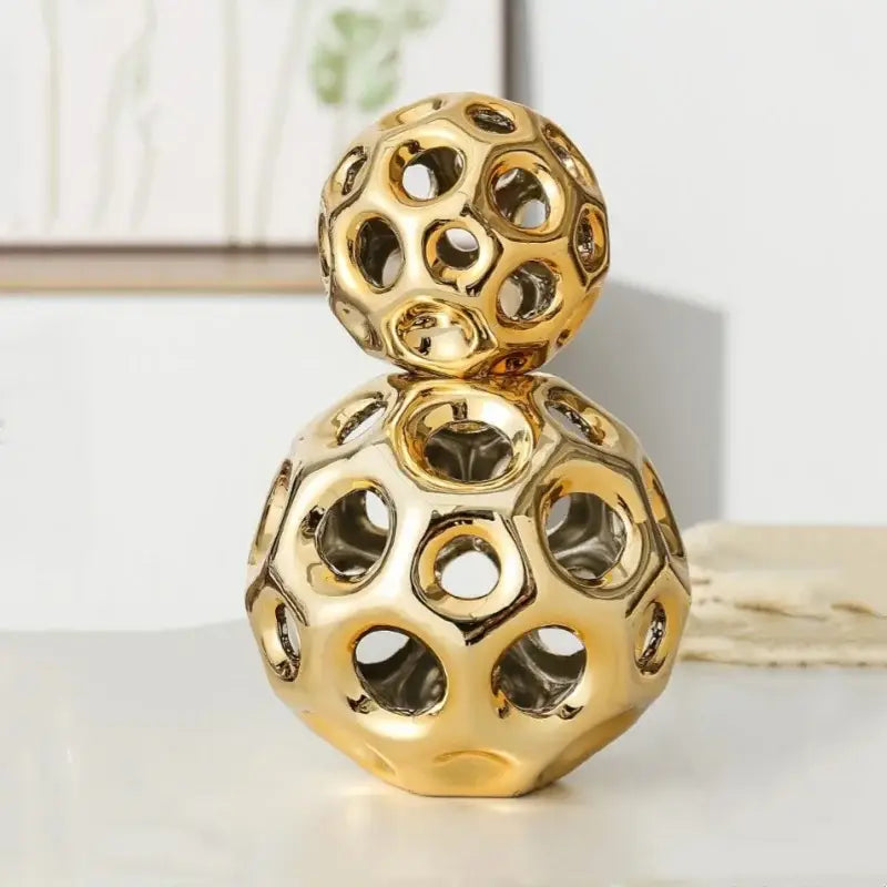 Golden hollow ceramic sculpture with two interconnected geometric golden hollow spheres for living room decorbites decor