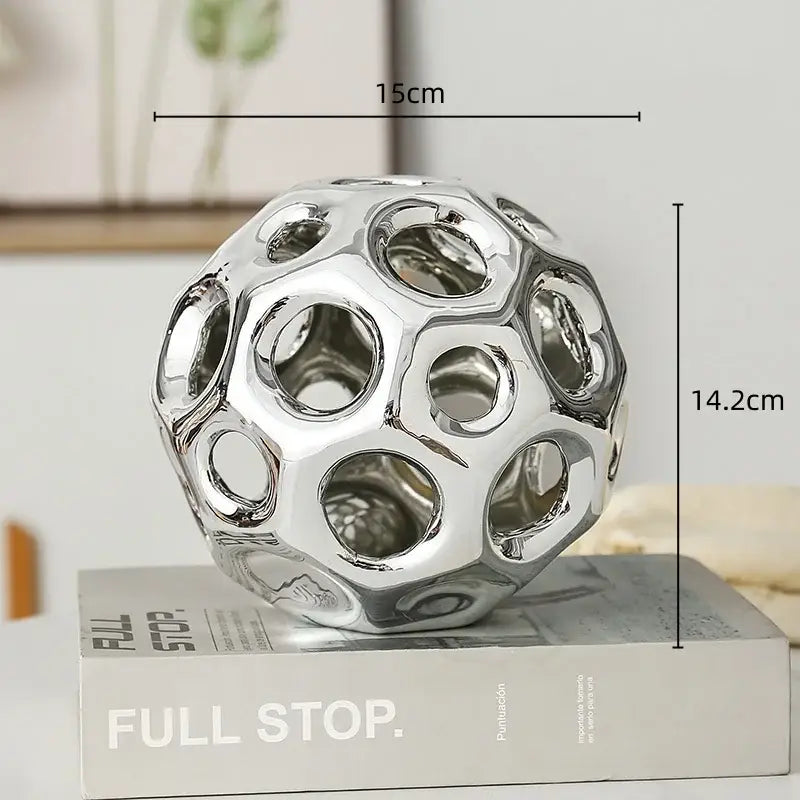 Shiny chrome-finished spherical decor with geometric perforated design for decorbites geometric golden hollow living room decor