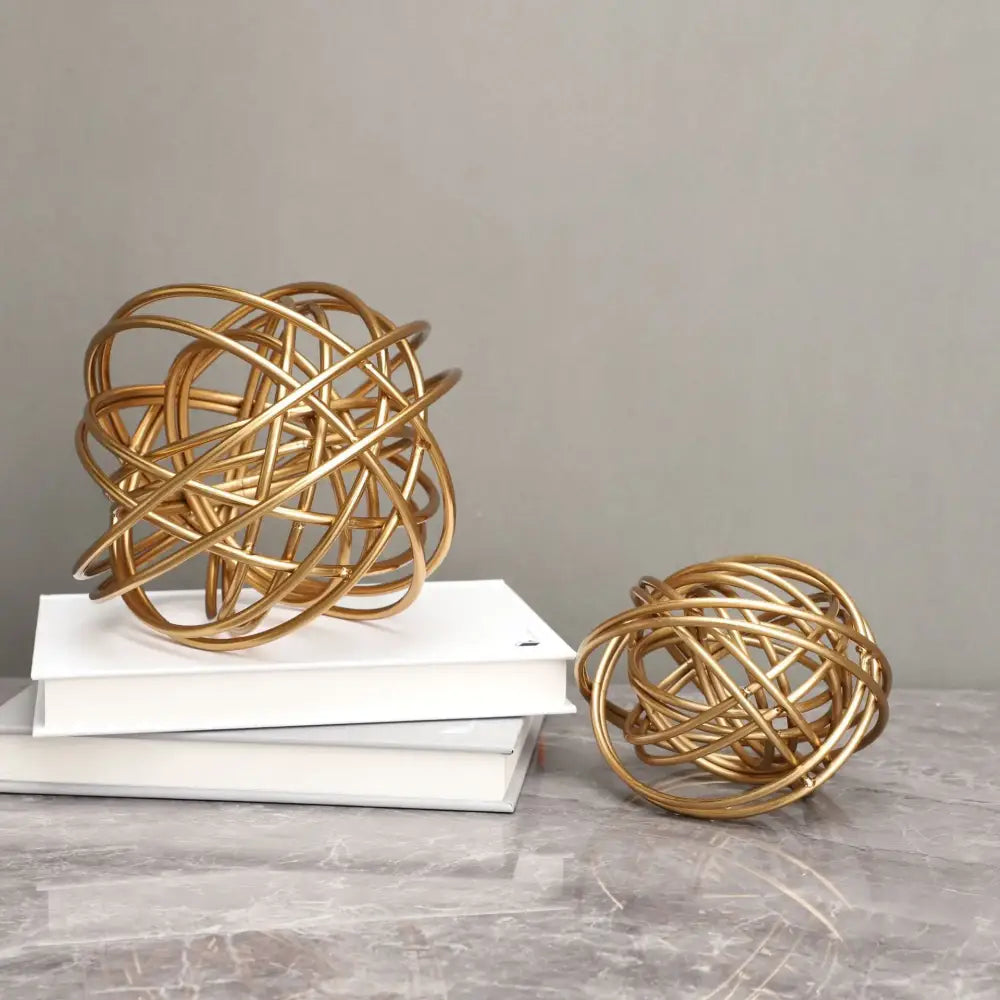 Golden wire decorative figurines with intertwined circular loops metal balls featured in decorbites geometric golden collection