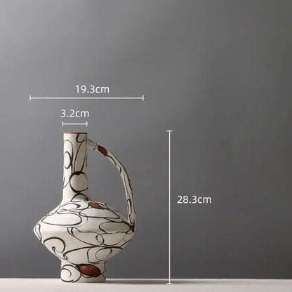 A white ceramic geometric graffiti vase with slender neck, curved handle, and black swirls for terracotta decorbites decor