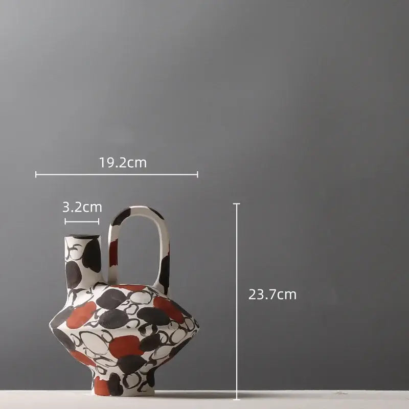 White ceramic geometric graffiti vase with black and terracotta abstract pattern and integrated handle for living room decor