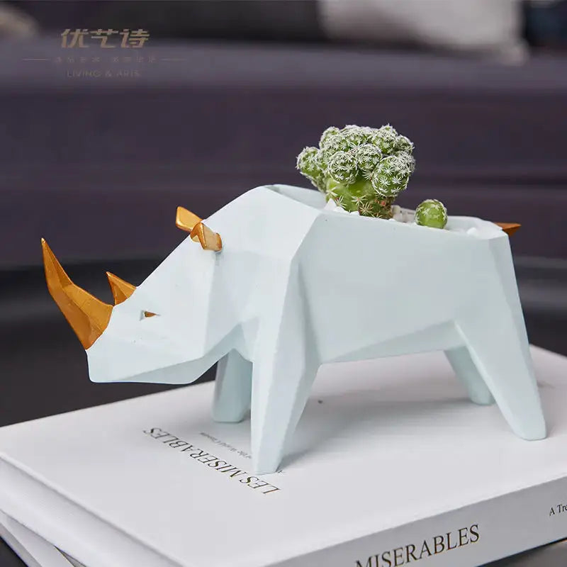 A light blue geometric rhinoceros planter with gold horns and cactus, styled like decorbites giraffe 3d papercraft sculpture
