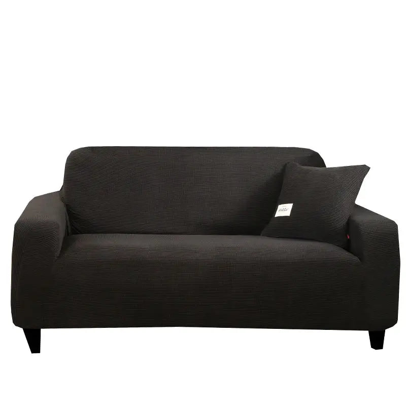 Black textured stretch sofa cover with matching pillow designed for living room use with a geometric gray pattern