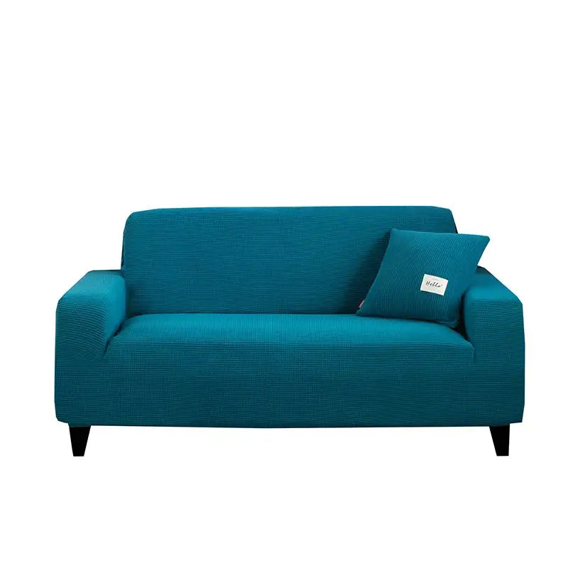 Teal textured stretch sofa cover with matching pillow complementing geometric gray textured living room décor
