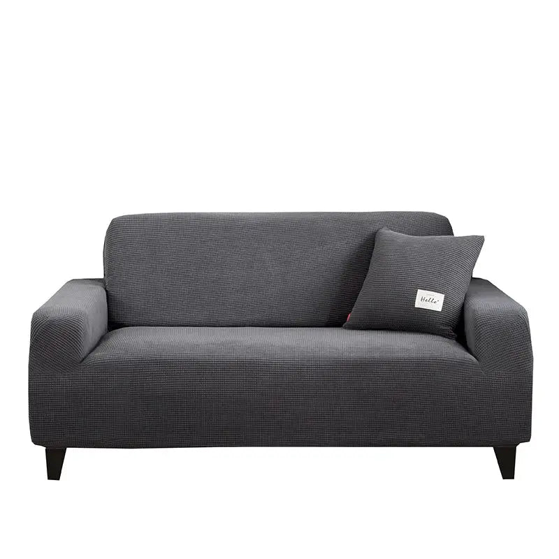 Dark gray geometric textured stretch sofa cover with matching pillow and black legs for living room use