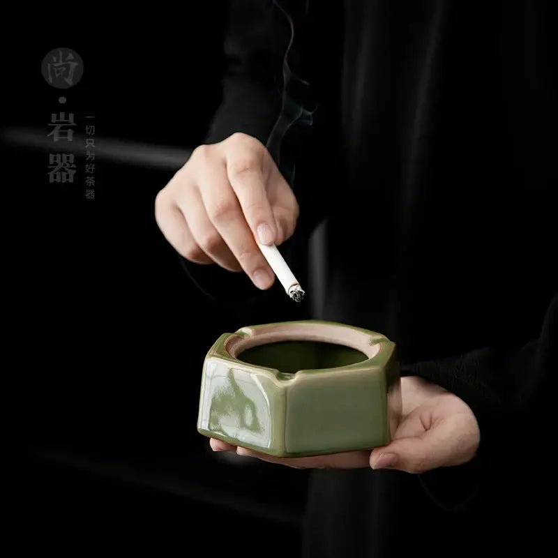 A geometric green ceramic ashtray with matte olive glaze and handle for easy grip ideal for office desk decorbites geometric green