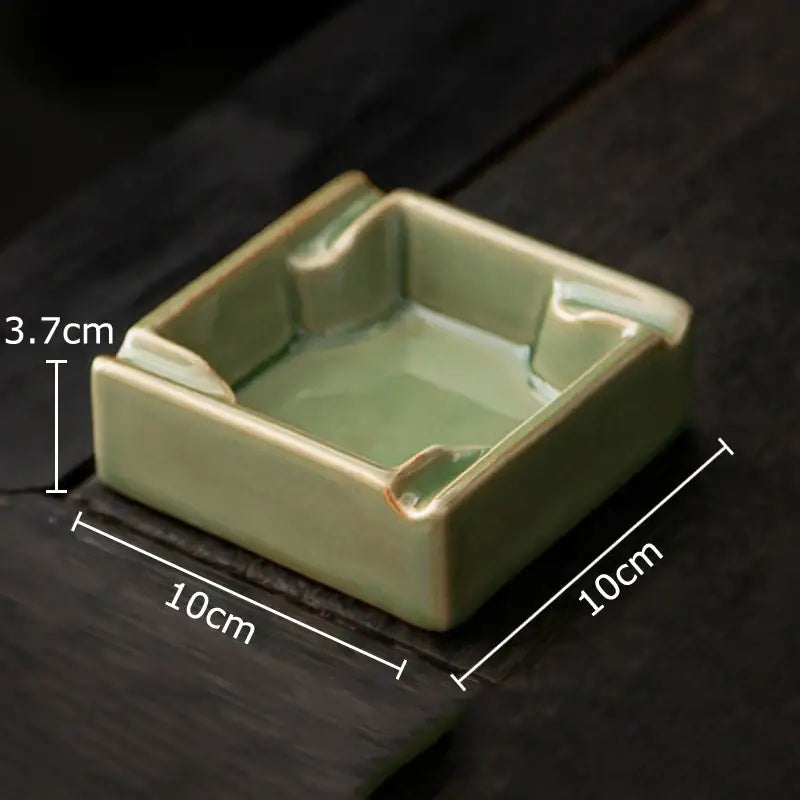 A geometric green ceramic ashtray with matte sage glaze and slightly raised rounded corners from decorbites for office desk decor
