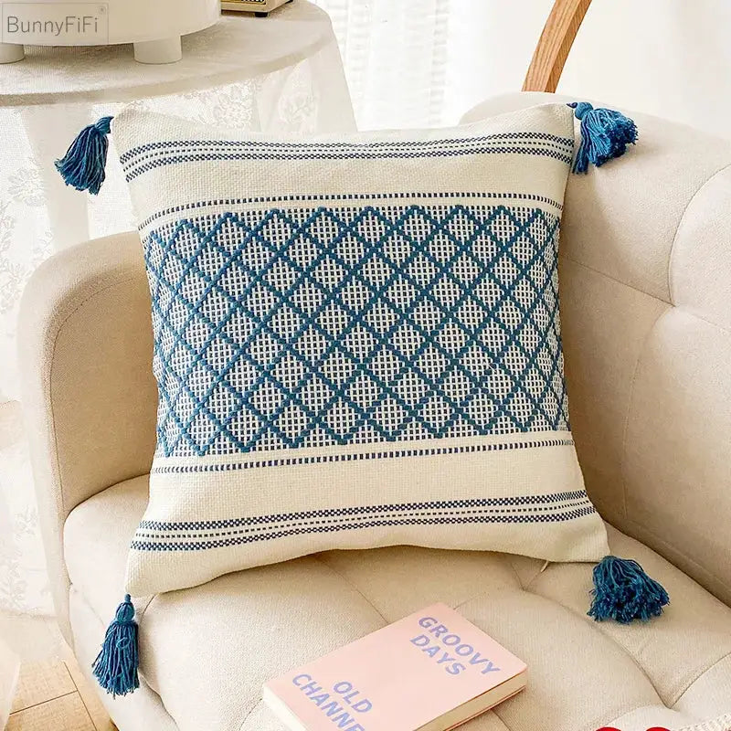 Cream-colored cushion cover with decorbites blue diamond jacquard pattern and matching tassels for living room decor