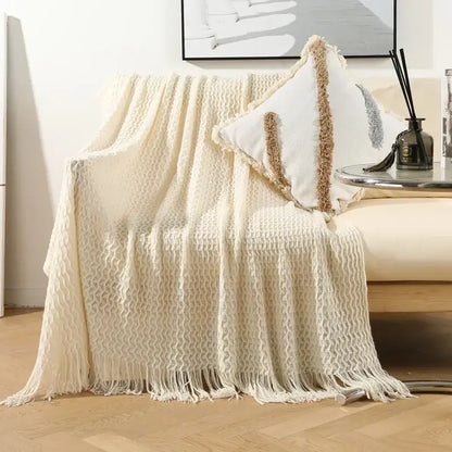 Cream-colored geometric knit sofa blanket with textured knit and fringe tassel detail by decorbites for living room decor