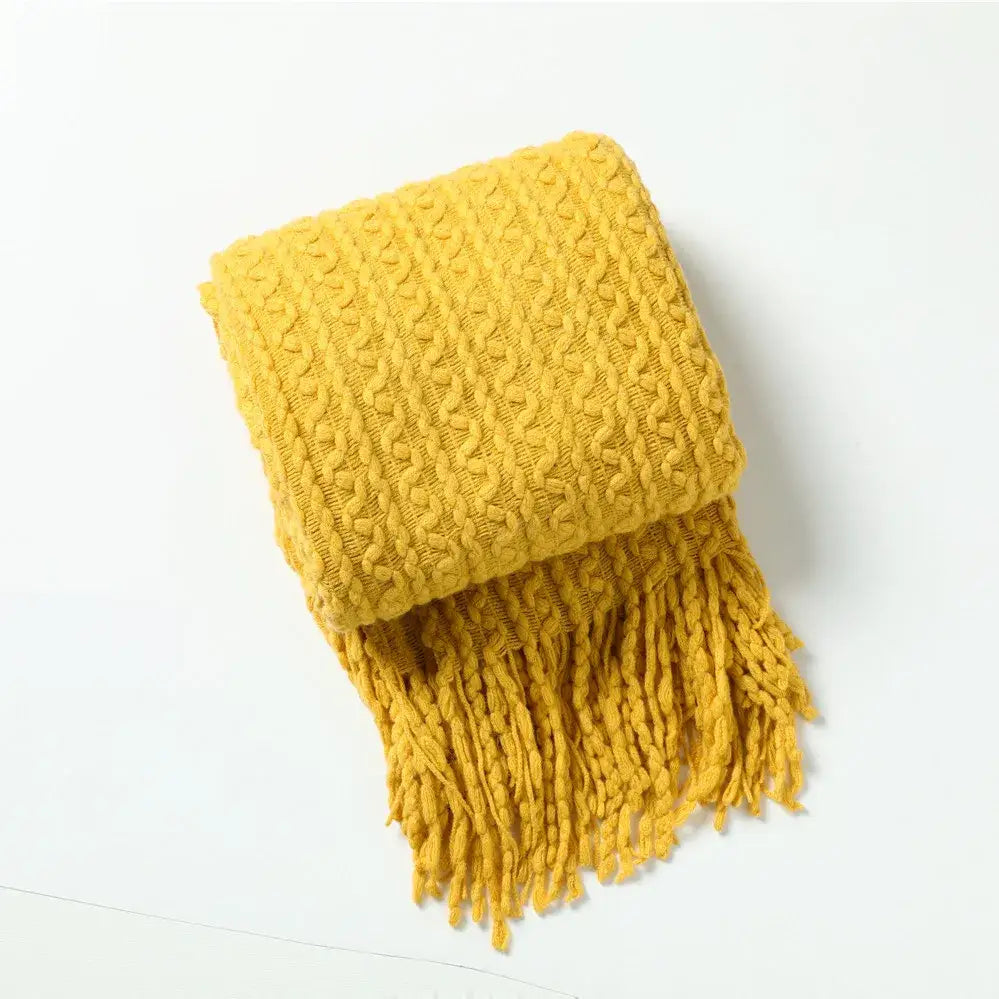 A cozy mustard-yellow knit sofa blanket with cable pattern and fringed ends perfect for decorbites geometric knit decor