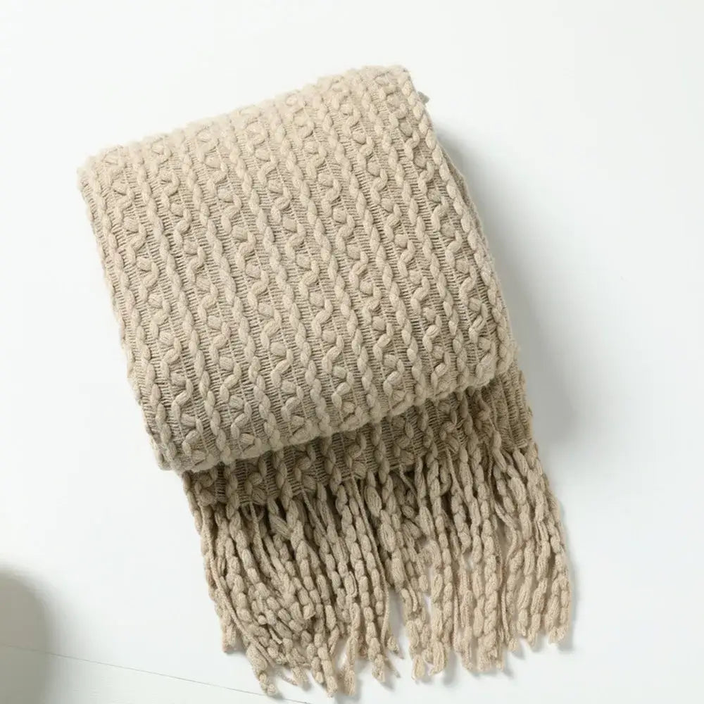 Beige knitted scarf with textured cable pattern and fringe displayed with decorbites geometric knit sofa blanket mustard and off white throw