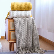 Stacked mustard yellow off-white and beige decorbites geometric knit sofa blankets with textured cable knit and tassels
