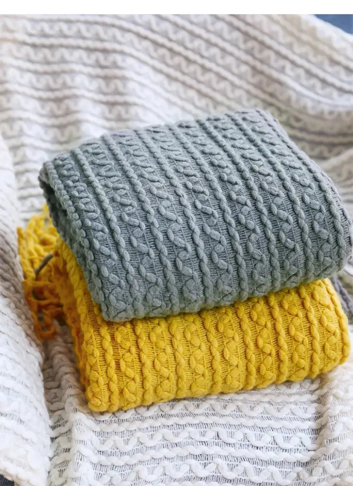 Stacked gray and yellow cable-knit sweaters with ribbed texture complement decorbites geometric knit sofa blanket mustard and off-white throw