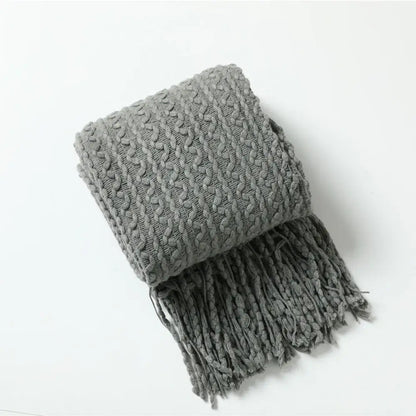 A cozy gray knitted scarf with a textured cable pattern and fringe for decorbites geometric knit sofa blanket use