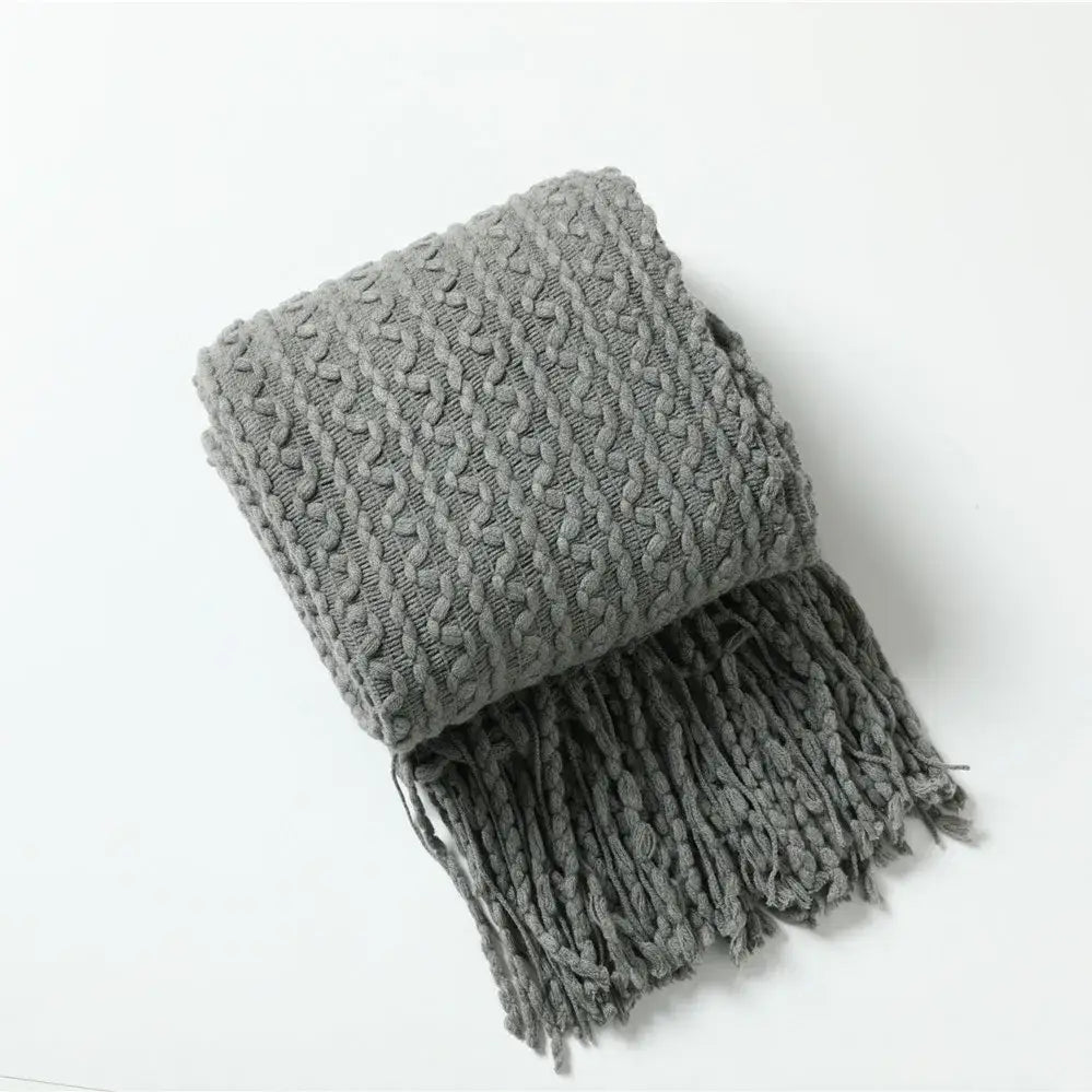 A cozy gray knitted scarf with a textured cable pattern and fringe for decorbites geometric knit sofa blanket use