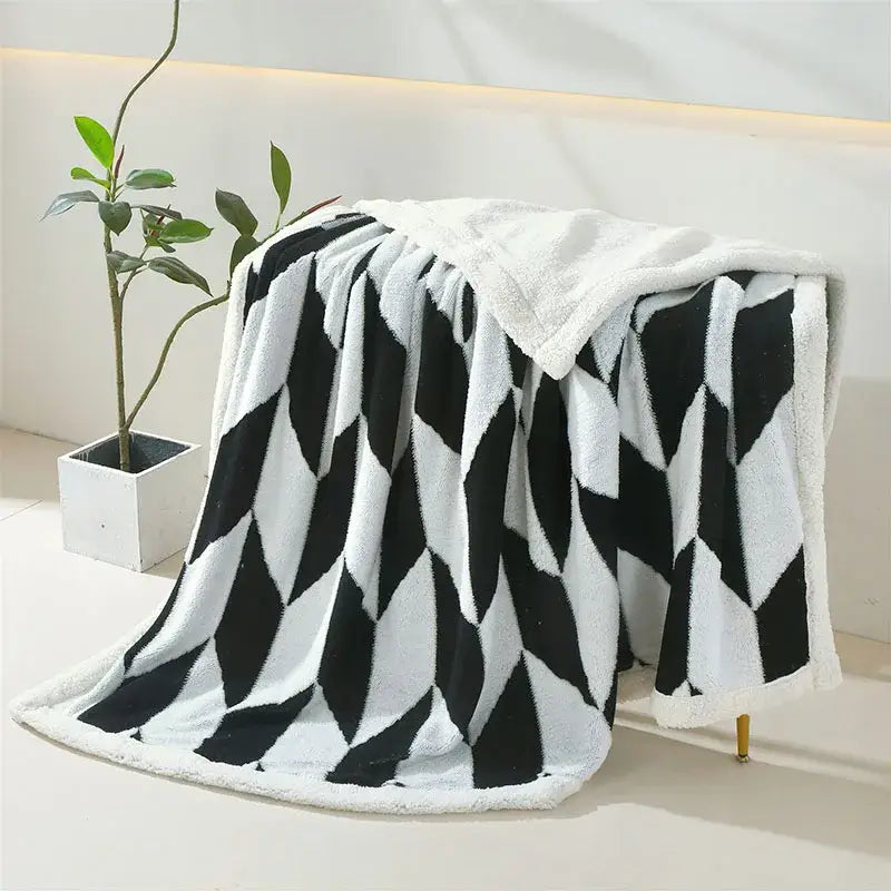 A plush black and white geometric lamb wool blanket with soft textured surface for cozy bedroom decorbites geometric lamb