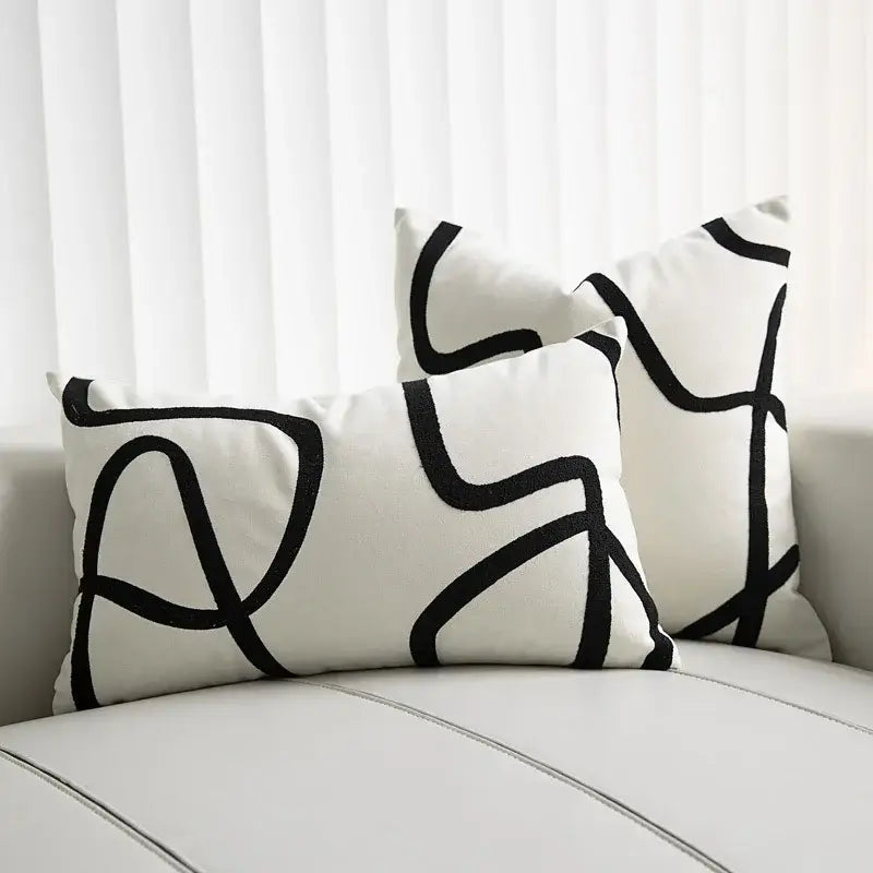 White rectangular throw pillows with bold black geometric line embroidered patterns in smooth fabric for living room decorbites geometric line