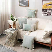 A geometrically patterned mosaic side table with triangular design in earthy tones complementing decorbites cotton crochet tassel cushion cover decor
