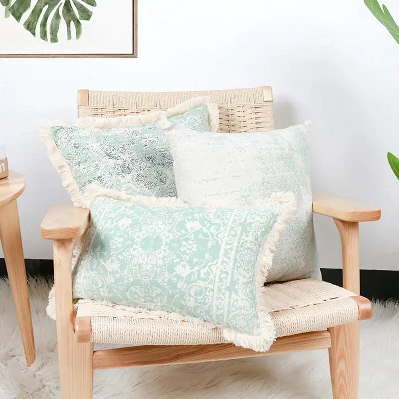 Three mint green and white geometric mosaic cotton crochet tassel cushion covers on rattan chair decorbites cotton crochet