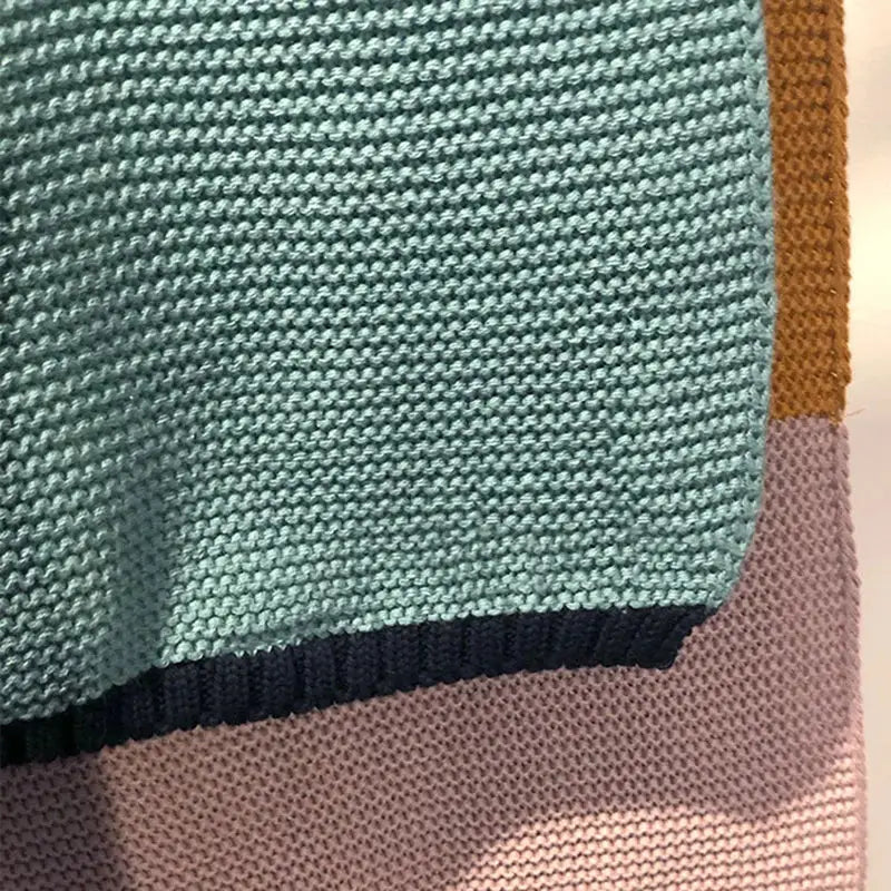 Teal decorbites knitted chenille blanket with textured ribbed pattern and dark navy trim for bedroom use