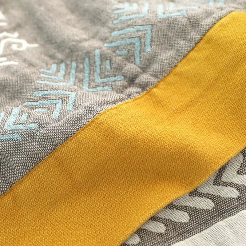 Geometric mustard and gray cotton gauze summer blanket with textured weave and light blue embroidery for decorbites cotton gauze