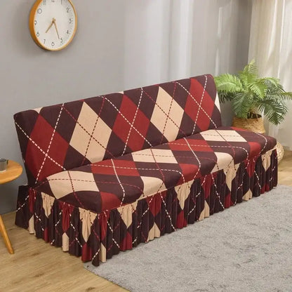 A cozy futon sofa covered with a stretchy argyle-patterned sofa cover in bold red and beige with white dotted lines