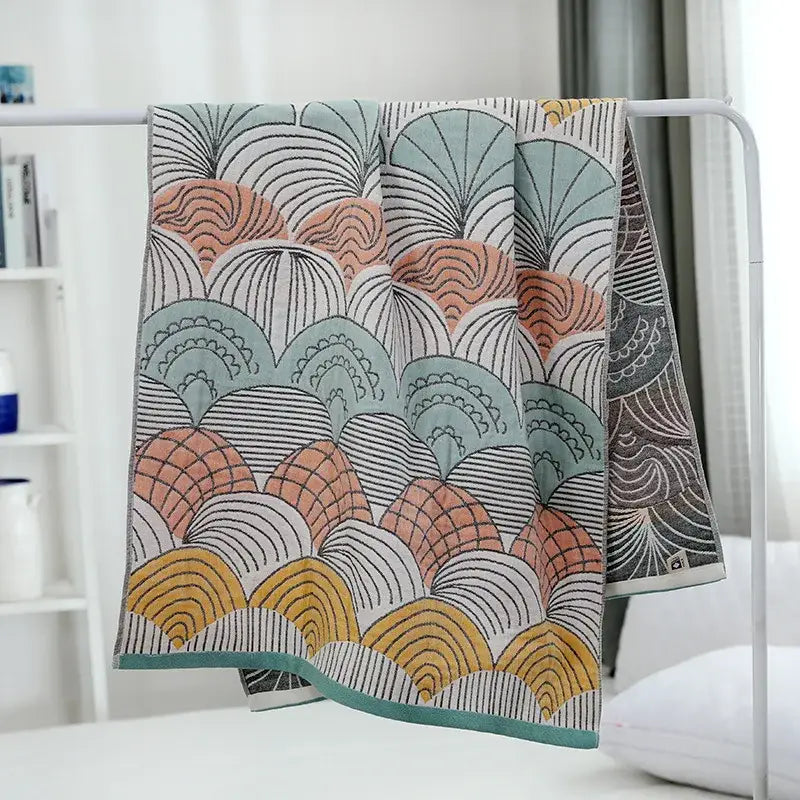 A multicolored bath towel in pastel teal peach and mustard yellow with black line details by decorbites cotton gauze bath