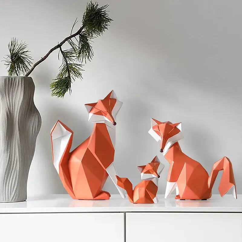Set of three geometric orange and white decorbites fox figurines with angular faceted designs for living room decor