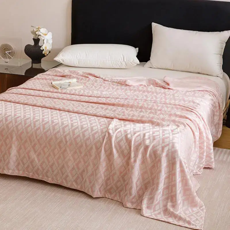 A soft pink geometric bamboo fiber summer blanket draped elegantly over the bed for lightweight bedding decorbites bamboo fiber