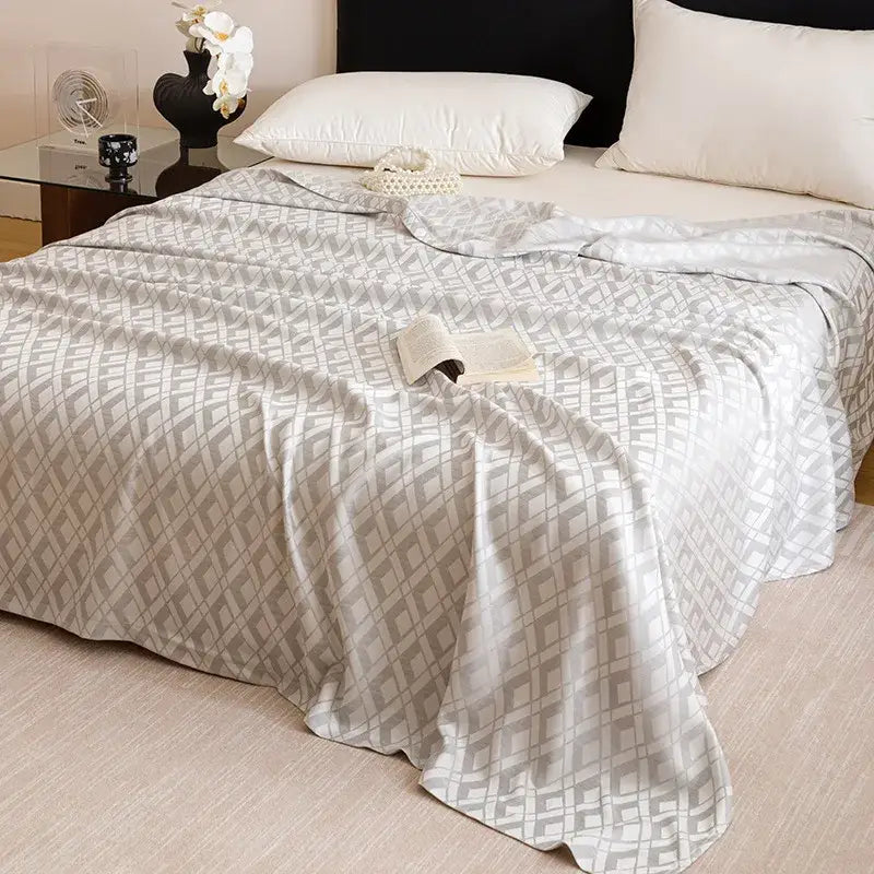 A soft light gray quilted bamboo fiber summer blanket with a subtle geometric pattern for lightweight bedding decorbites