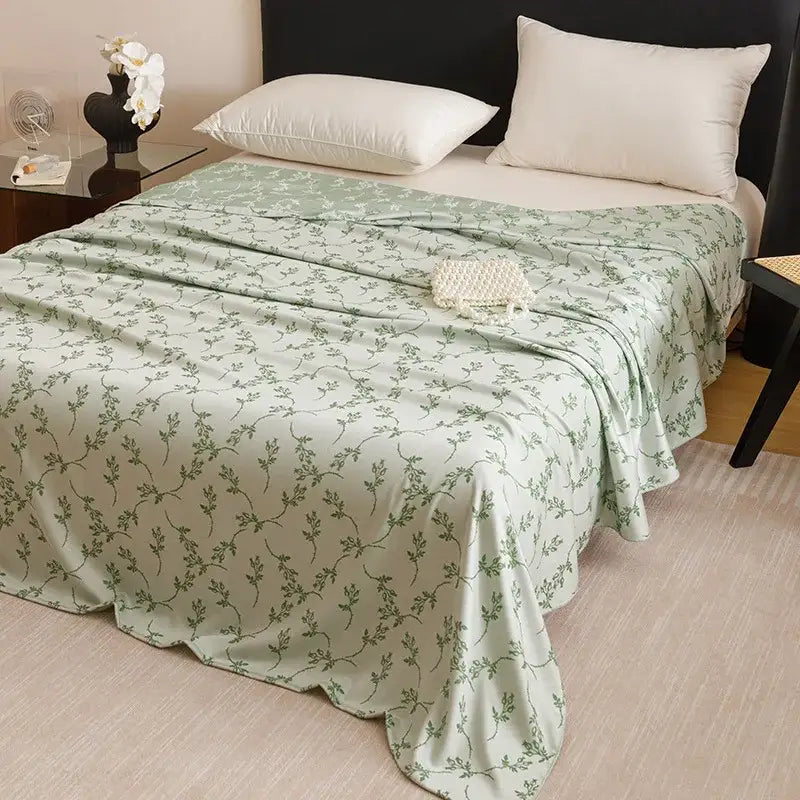 A soft mint green bamboo fiber summer blanket with dark green vine pattern for lightweight bedroom bedding