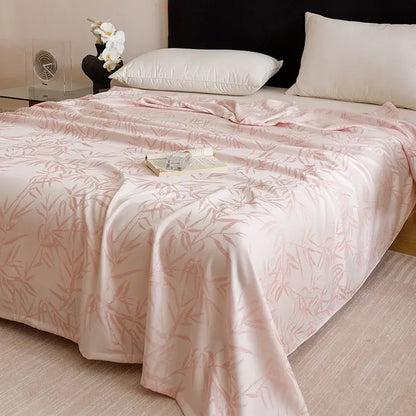 A soft pink satin bamboo fiber summer blanket with a subtle geometric bamboo leaf pattern for lightweight bedding