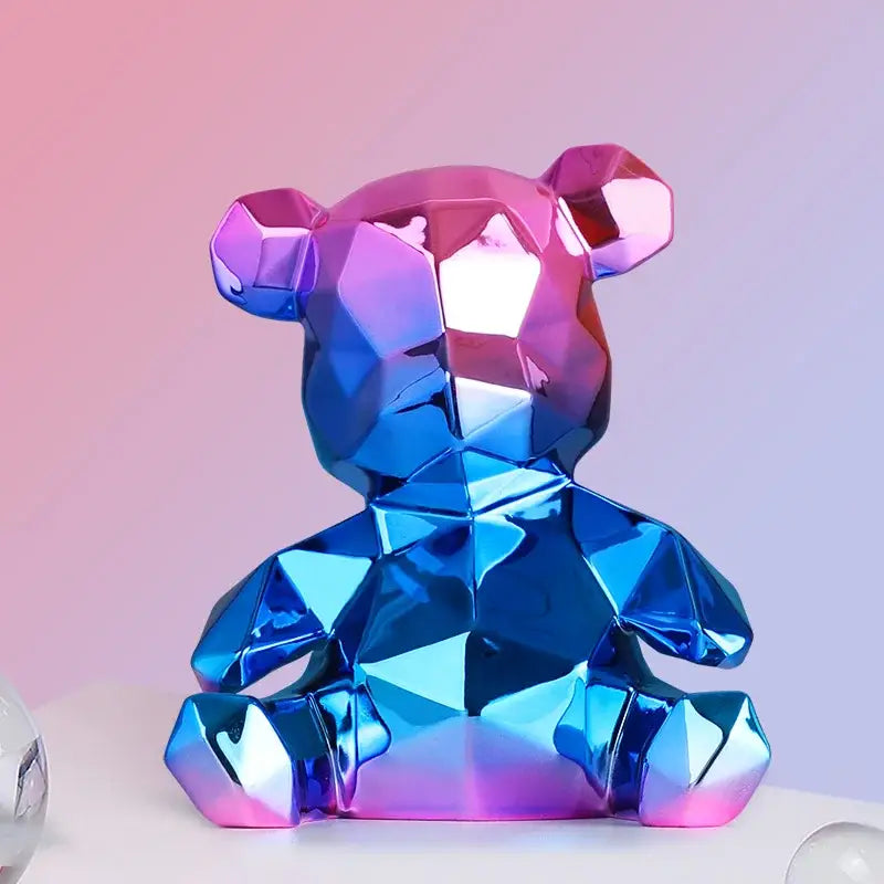 A glossy electroplated teddy bear sculpture with geometric design in pink and blue hues for living room decor