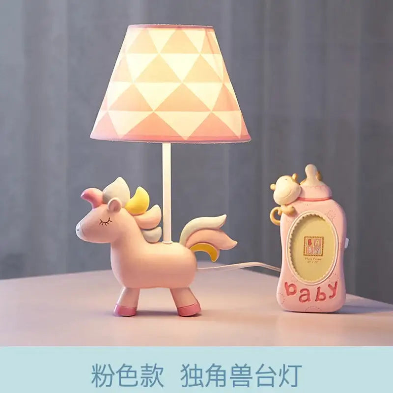 Pink unicorn table lamp with geometric-patterned shade in pink and blue for children’s bedroom décor