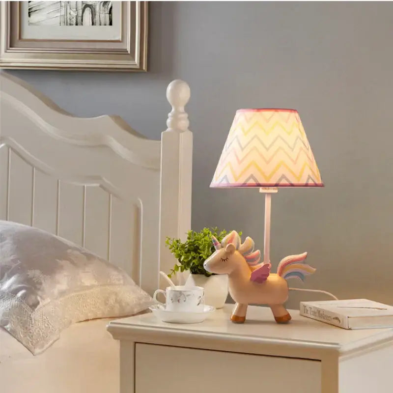 Pastel pink unicorn table lamp with colorful zigzag-patterned shade for children’s bedroom lighting
