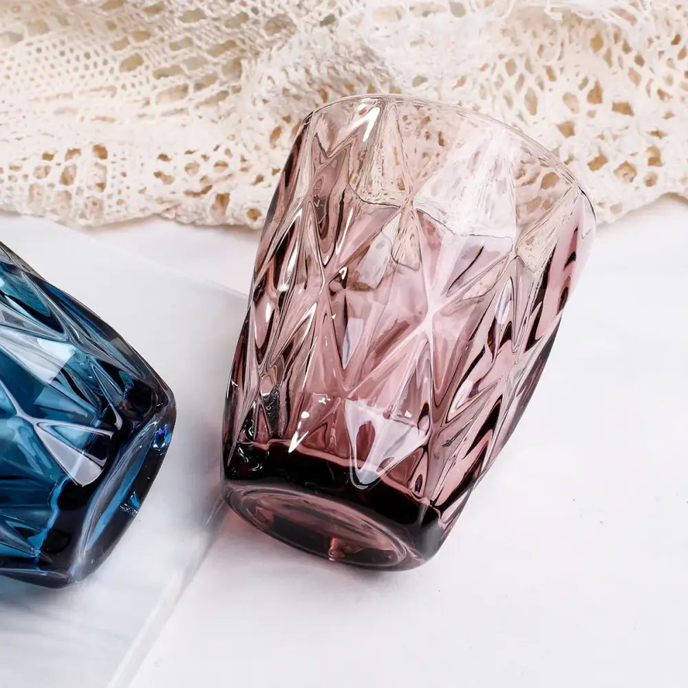 A faceted translucent pink glass 240ml water glass drinkware with a geometric cut pattern for dining room use