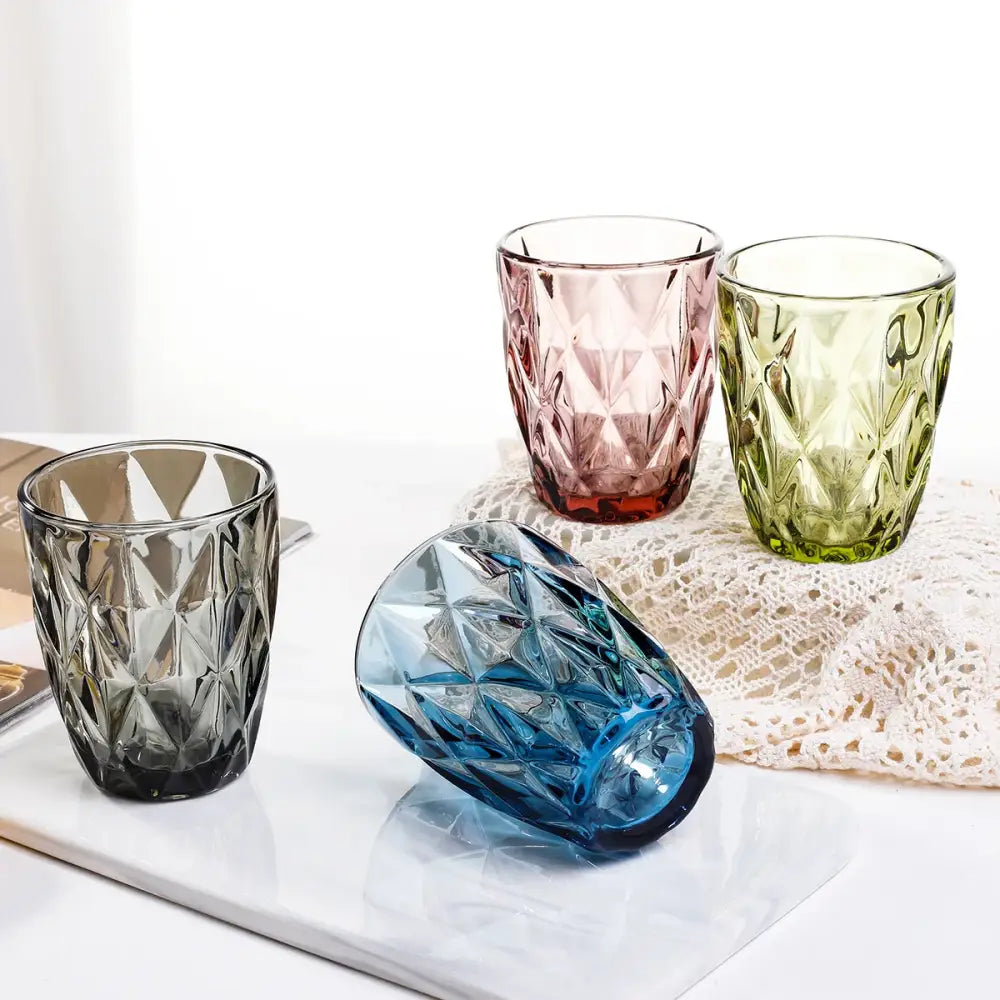 Set of four colorful geometric faceted 240ml water glass drinkware in pink green gray and blue for dining room use