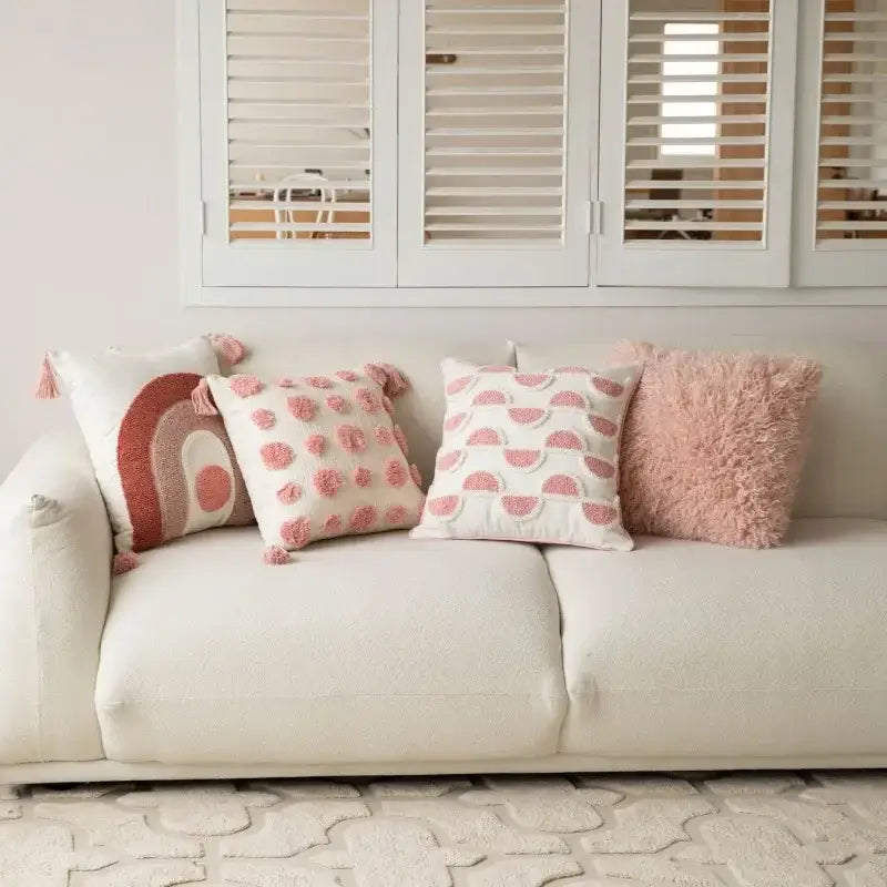 Soft fluffy pink and white geometric embroidered pillow covers with pom-pom accents on cream sofa decorbites cushion covers