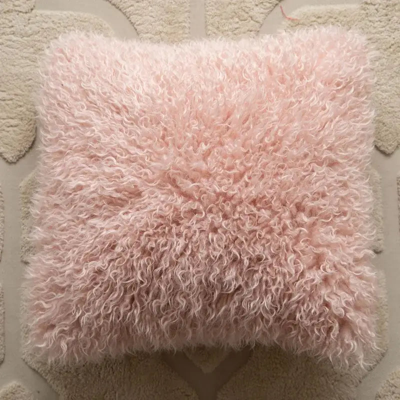 A soft fluffy pink sheepskin pillow with plush curly texture complementing decorbites geometric embroidered cushion covers