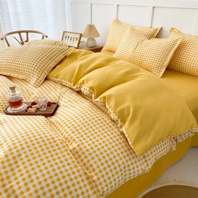 Yellow and white gingham quilt cover set with ruffled edges for bedroom featuring a geometric pink and white design