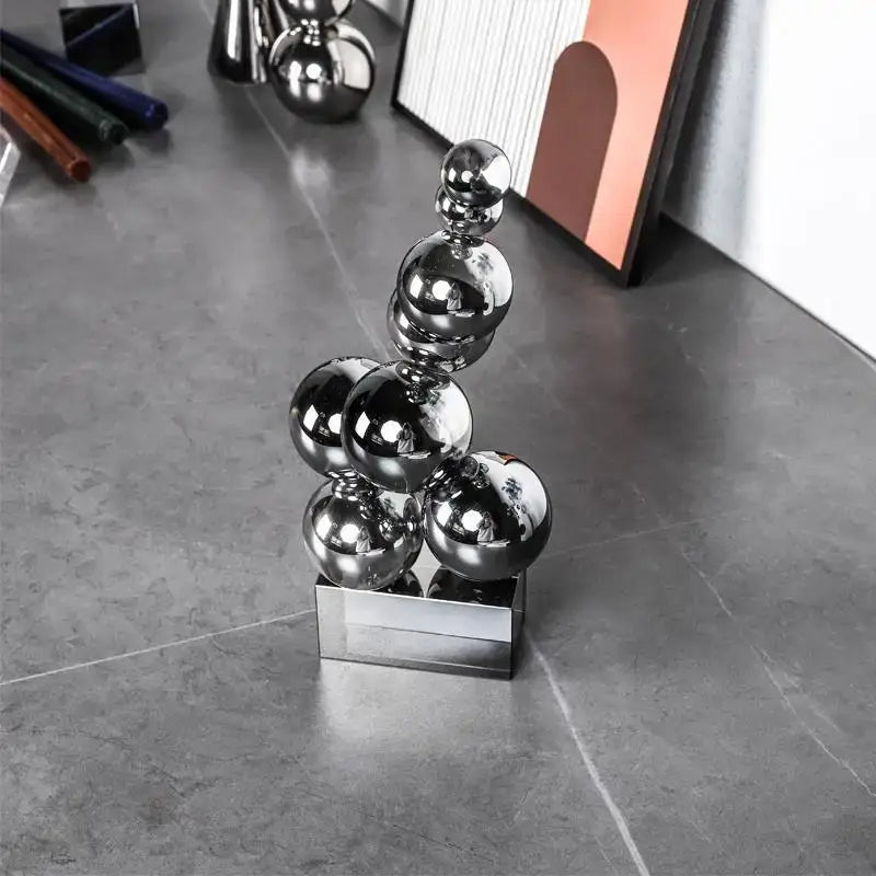 Shiny chrome spheres stacked in a geometric crystal sculpture silver ball on a metallic base for living room decor